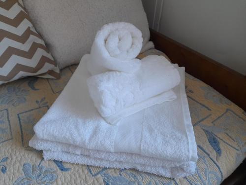 een stapel handdoeken bovenop een bed bij La gran sirena in Cuchilla Alta