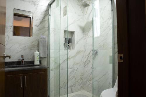 uma casa de banho com uma cabina de duche em vidro e um lavatório. em Casa en puebla em El Gallinero