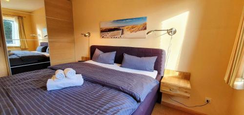 een slaapkamer met een bed met twee handdoeken erop bij FeWo-Nordsee-Whg-11 in Sankt Peter-Ording