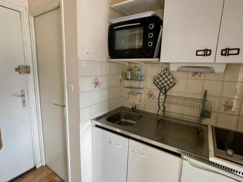une petite cuisine avec un évier et un micro-ondes dans l'établissement Studio douillet près des Thermes avec parking privatif - FR-1-555-97, à Aix-les-Bains