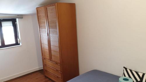 d'une armoire en bois dans un coin de chambre. dans l'établissement Central Lisbon Sao Jorge 2 bedroom private apartment, à Lisbonne