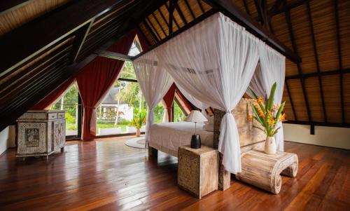 Anima Retreat Bali في Krambitan: غرفة نوم مع سرير مظلة في غرفة