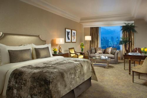 a bedroom with a large bed and a living room at Hotel Mulia Senayan, Jakarta in Jakarta