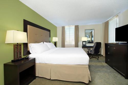 a hotel room with a large bed and a desk at Holiday Inn New Orleans West Bank Tower, an IHG Hotel in Gretna