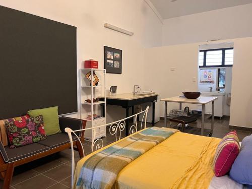 a bedroom with a bed and a desk and a table at Quiet Rural Retreat in Howard Springs