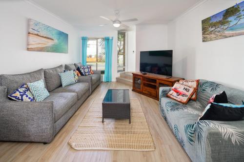 a living room with two couches and a flat screen tv at Growder Court 3 - Coolum Beach QLD in Coolum Beach