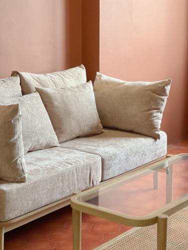 a living room with a couch and a glass table at SO Zen Hotel Silom Bangkok in Bang Rak