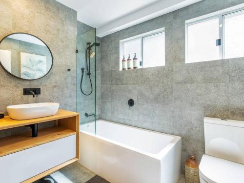 uma casa de banho com uma banheira, um lavatório e um espelho. em Town & Tide em Lennox Head