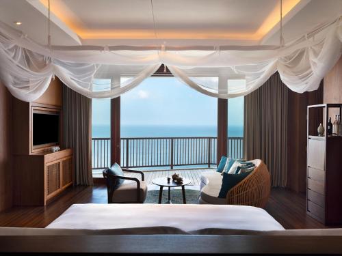 a bedroom with a bed and a view of the ocean at Six Senses Uluwatu in Uluwatu