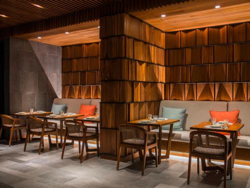 a restaurant with wooden walls and tables and chairs at Six Senses Uluwatu in Uluwatu