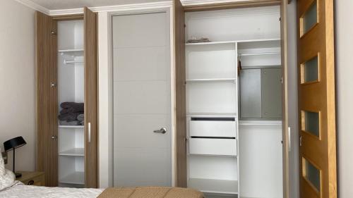 1 dormitorio con armario con estanterías blancas en Apartamento nuevo en Centro de Viña del Mar, Parque Urbano, en Viña del Mar