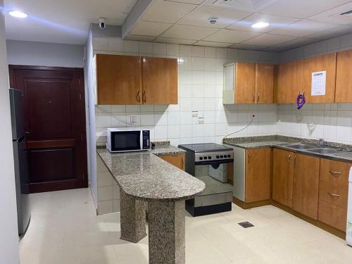 a kitchen with wooden cabinets and a granite counter top at Private Partition Room Near Mashreq Metro in Dubai