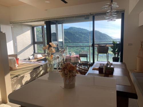 a kitchen with a table with a view of a mountain at 怡蘭灣海景溫泉 in Hsin-hsing