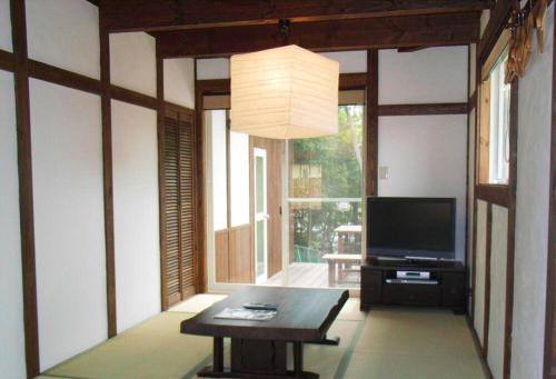 a living room with a television and a table at 天然温泉！古民家風の貸切り一軒家 【白山リバーサイドコテージ 】2-120号棟 in Nihongi