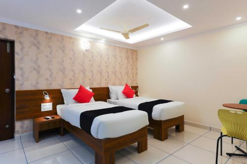 a hotel room with two beds with red pillows at Super Collection O Companion Leisure Homes in Kovalam