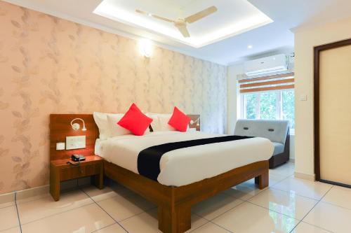 a bedroom with a large bed with red pillows at Companion Leisure Homes in Kovalam