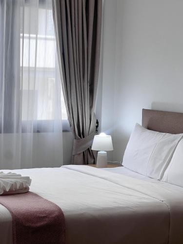 a bedroom with a white bed with a window at SO Zen Hotel Silom Bangkok in Bang Rak