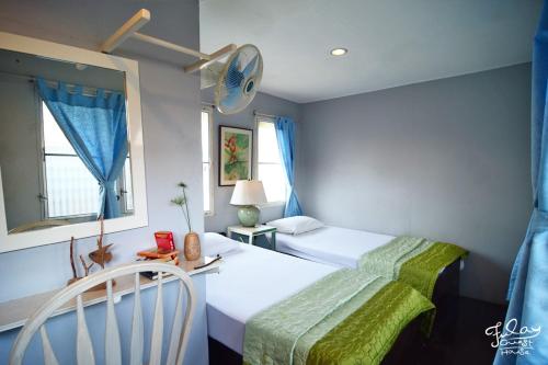 a small bedroom with two beds and a fan at Fulay Guesthouse Hua Hin in Hua Hin