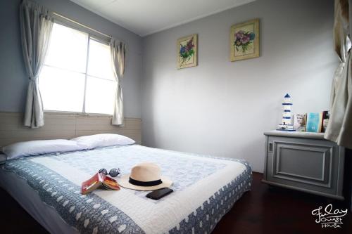 a bedroom with a bed with a hat and shoes on it at Fulay Guesthouse Hua Hin in Hua Hin