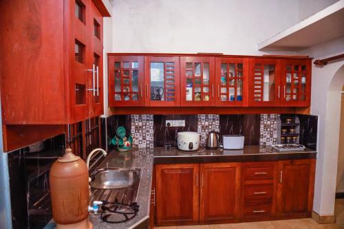 una cocina con armarios de madera y fregadero en Vision Home, en Ambalangoda