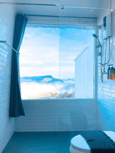 a bathroom with a window with a view of the ocean at La Montagne Doi Chang in Ban Huai Khai
