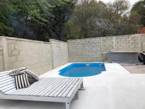 una piscina con banco y piscina en CASA RIO CEBALLOS en Río Ceballos