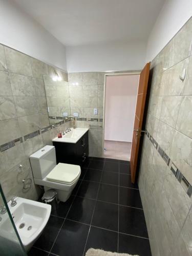 La salle de bains est pourvue de toilettes blanches et d'un lavabo. dans l'établissement CASA RIO CEBALLOS, à Río Ceballos
