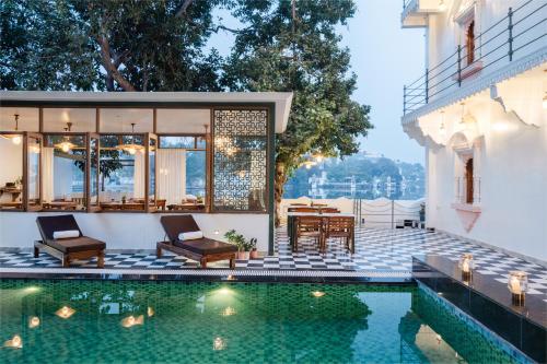 a house with a swimming pool and a patio at The Experience Resort-Lake Facing in Udaipur