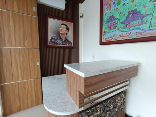 a bathroom with a sink with a picture on the wall at The Cabin Hotel Sumberan in Yogyakarta