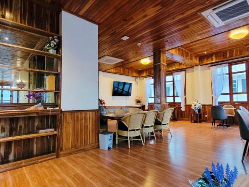 um quarto amplo com pisos em madeira, uma mesa e cadeiras em Kum-Chan House Hotel (เฮือนก่ำจันทร์) em Nan