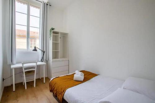 une chambre avec un lit, un bureau et une fenêtre dans l'établissement Appartement 2 chambres, calme garanti, à Lyon