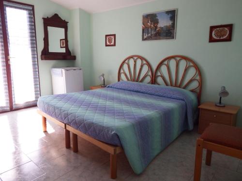 ヴィッラ・サン・ピエトロにあるCasa vacanza Corneliaのベッドルーム1室(青い掛け布団付きのベッド1台付)