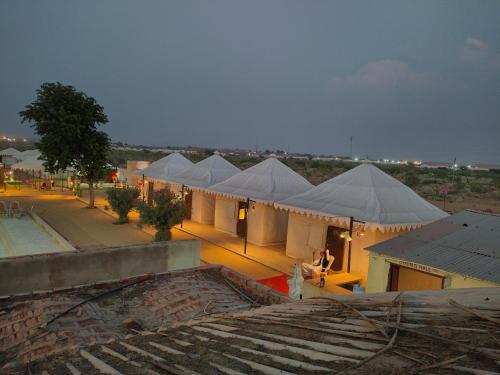 a row of white tents with people under them at Mariyan Desert Safari Camp in Sām