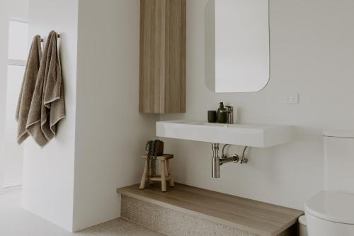 a bathroom with a white sink and a mirror at Middle River Vista Beach House in Stokes Bay