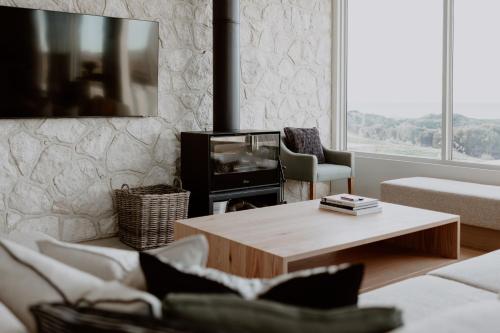 a living room with a coffee table and a tv at Middle River Vista Beach House in Stokes Bay
