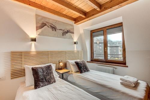 une chambre avec deux lits et une fenêtre dans l'établissement Apartment Alpes V - Alpes Travel - Central Chamonix - Sleeps 5, à Chamonix-Mont-Blanc