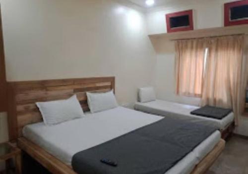 um quarto com 2 camas e uma janela em Hotel Regency Maharashtra em Amravati