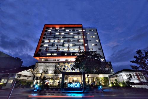 a tall building with a sign in front of it at THE 1O1 Palembang Rajawali in Palembang