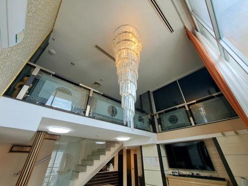 un lustre suspendu au plafond d'un bâtiment dans l'établissement Custom Design Loft With City Views And Rooftop Pool, à Makkasan
