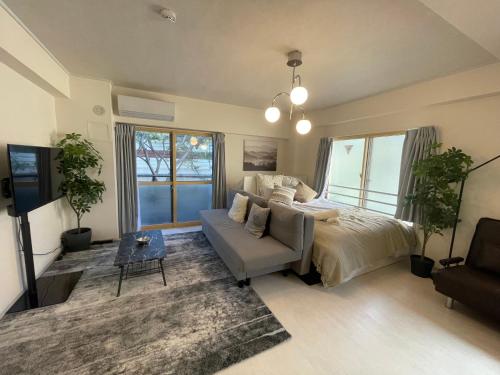 a bedroom with a bed and a couch at Oak Stay Shimokitazawa Luxury Family size 2min Shimokitazawa sta Shinjuku Shibuya7min by train in Tokyo