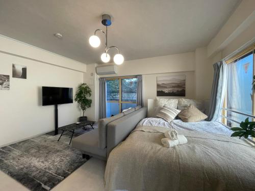 a bedroom with a bed and a tv and windows at Oak Stay Shimokitazawa Luxury Family size 2min Shimokitazawa sta Shinjuku Shibuya7min by train in Tokyo