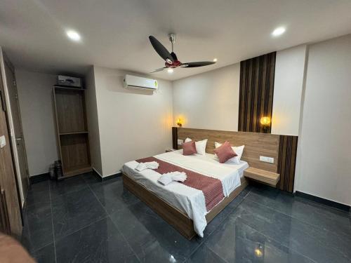 a bedroom with a bed and a ceiling fan at Namay Inn By T AND M Hotels in Haridwār