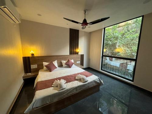 a bedroom with a bed with a ceiling fan at Namay Inn By T AND M Hotels in Haridwār