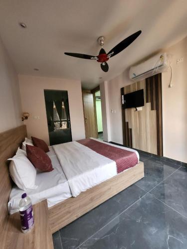 um quarto com uma cama e uma ventoinha de tecto em Namay Inn By T AND M Hotels em Haridwar