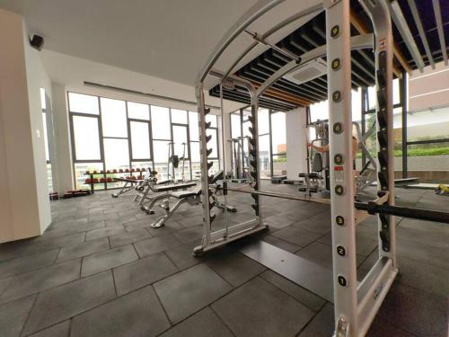a gym with treadmills and machines in a room at Near Airport K Avenue Family Room in Donggongon