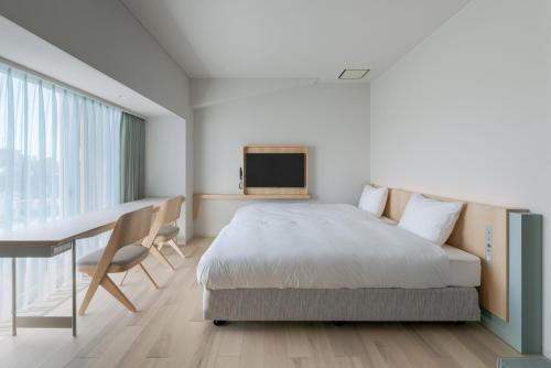 - une chambre avec un lit, un bureau et une télévision dans l'établissement ITOMACHI HOTEL0, à Saijo
