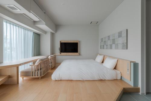 um quarto com uma cama, uma secretária e uma televisão em ITOMACHI HOTEL0 em Saijo