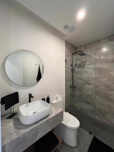 a bathroom with a sink and a toilet and a mirror at Apartamento de Lujo en Quito in Quito