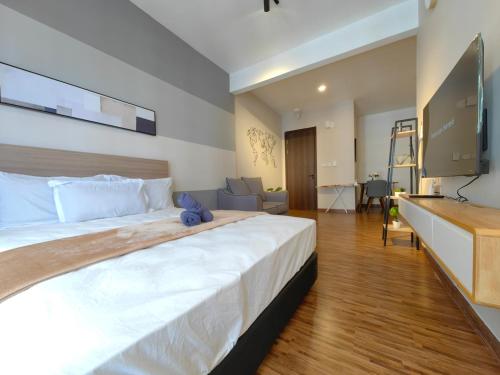 a bedroom with a large bed with a tv on the wall at Near Airport K Avenue Family Room in Donggongon