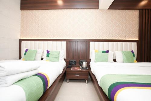 two beds sitting next to each other in a room at Hotel Neelkiran in Navi Mumbai